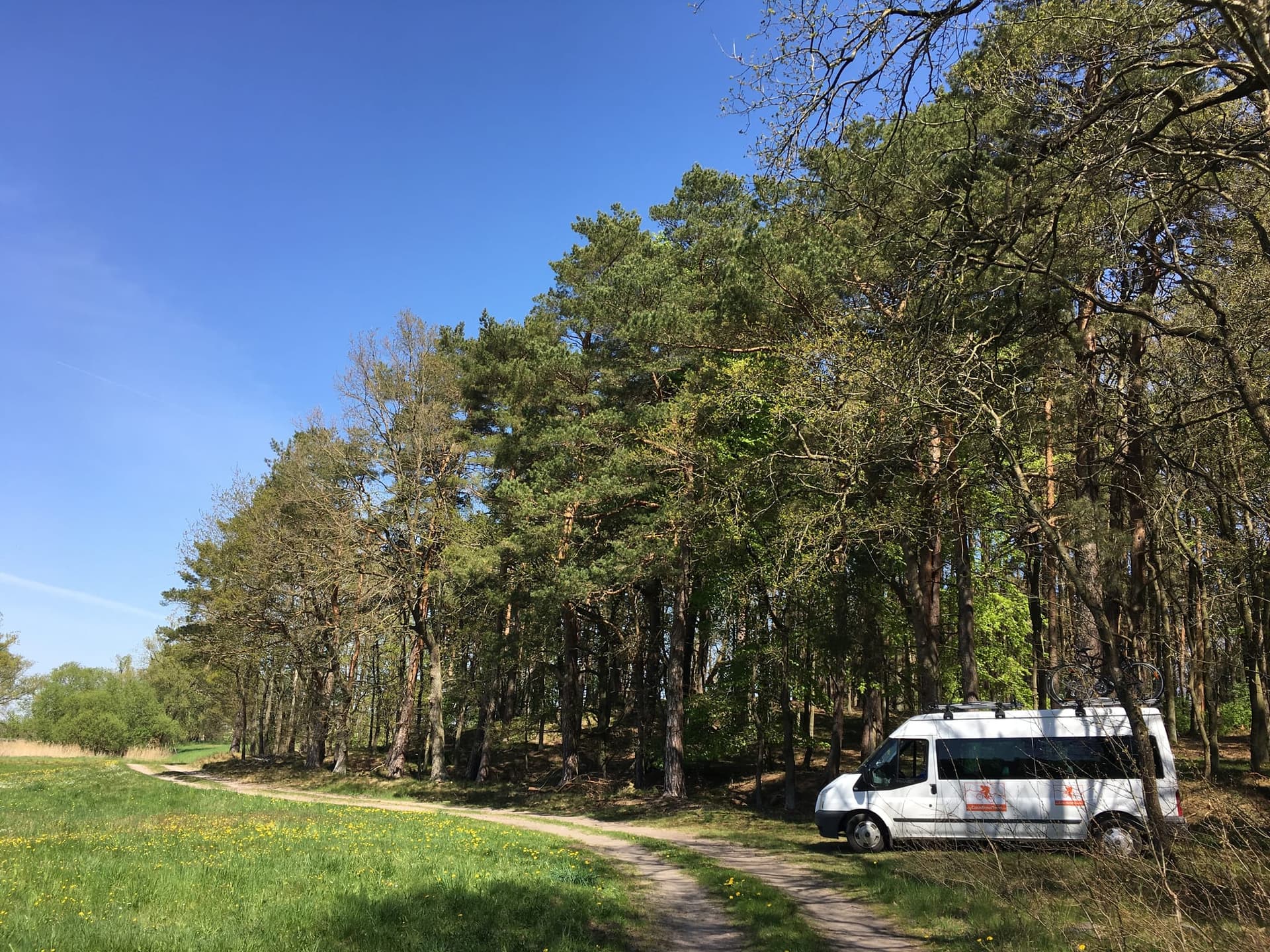 The Best European Bike Tours support van parked beside a route with bikes on the roof rack